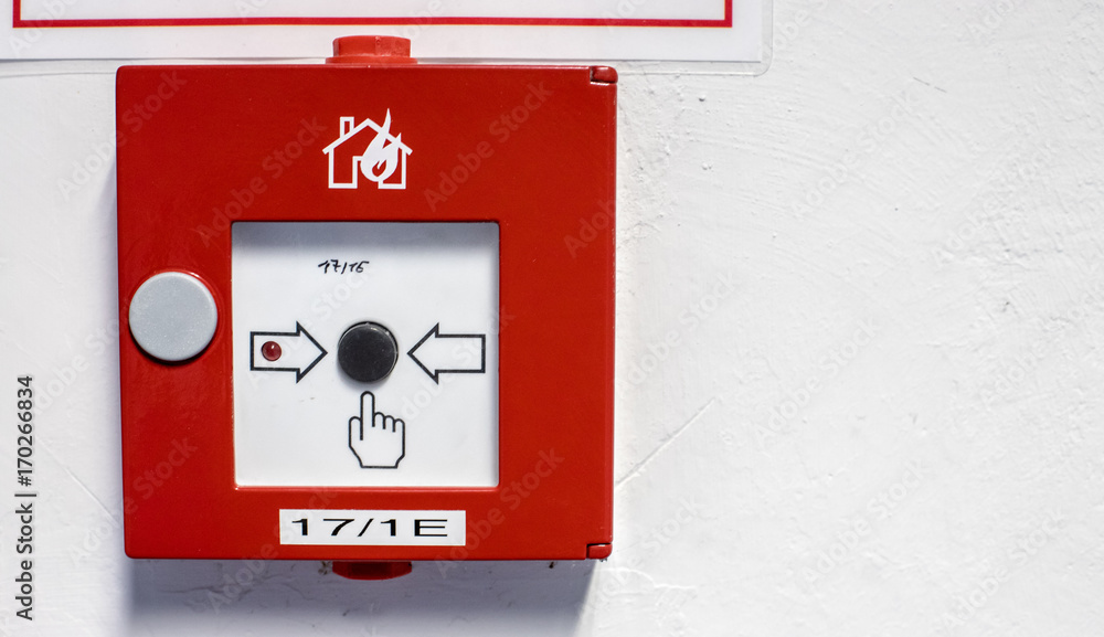 Roter Handfeuermelder an einer Wand.