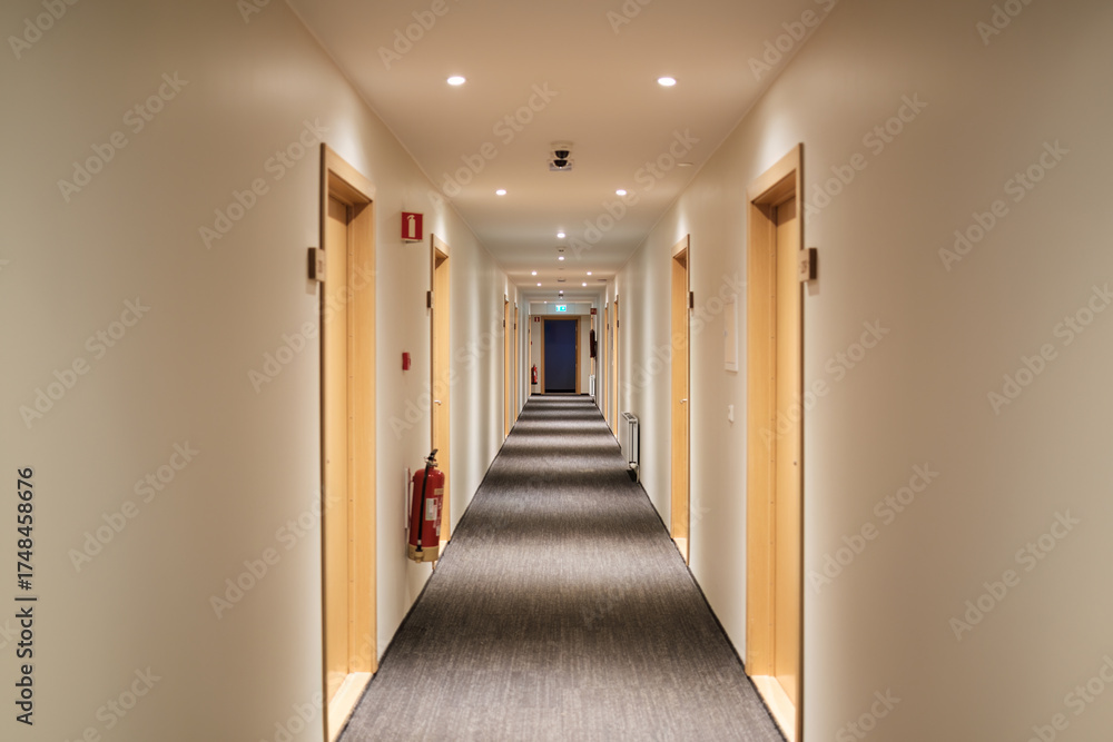 Hotelflur mit Zimmertüren und Feuerlöscher.